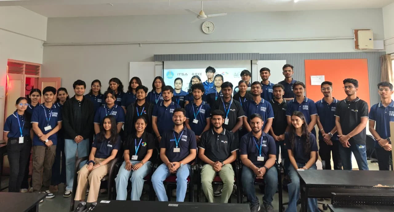 A group of students wearing dark blue shirts posing together in a classroom